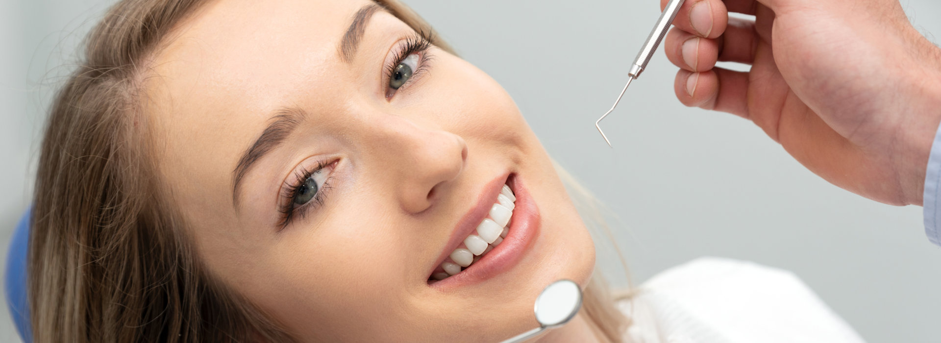 A woman is smiling with dental bridges.